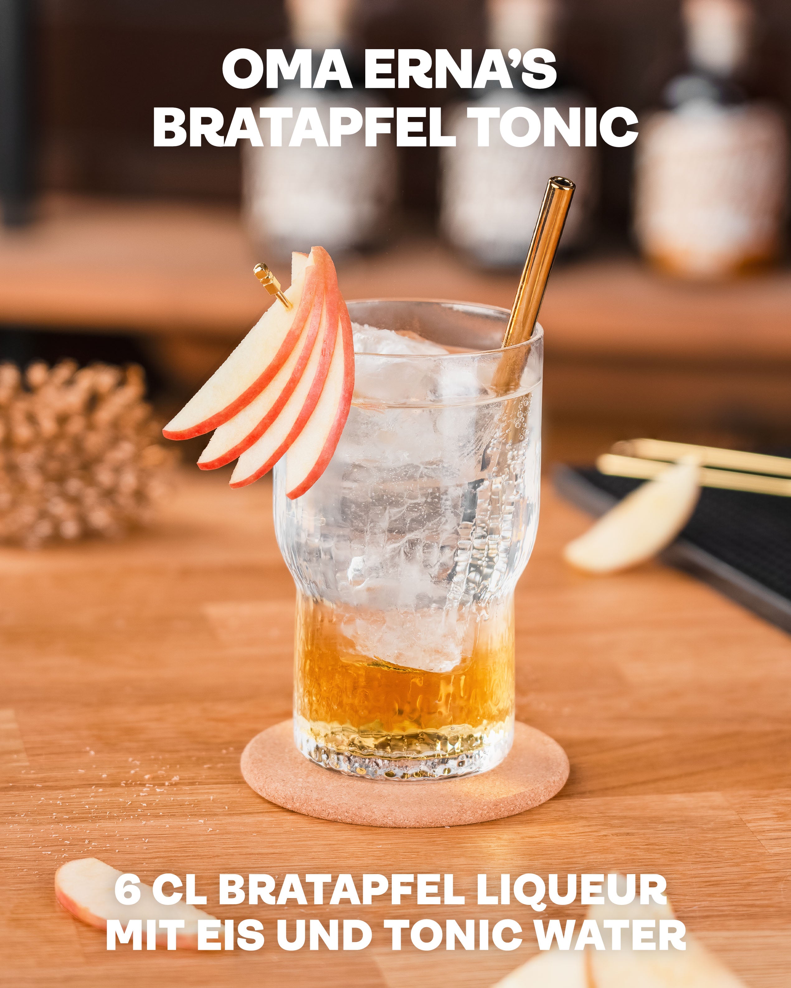 Oma Ernas Bratapfel Tonic, Glas mit Likör und Tonic, dekoriert mit dünnen Apfelscheiben und goldenem Strohhalm, auf hellem Holzuntergrund vor Bar-Regal im Hintergrund