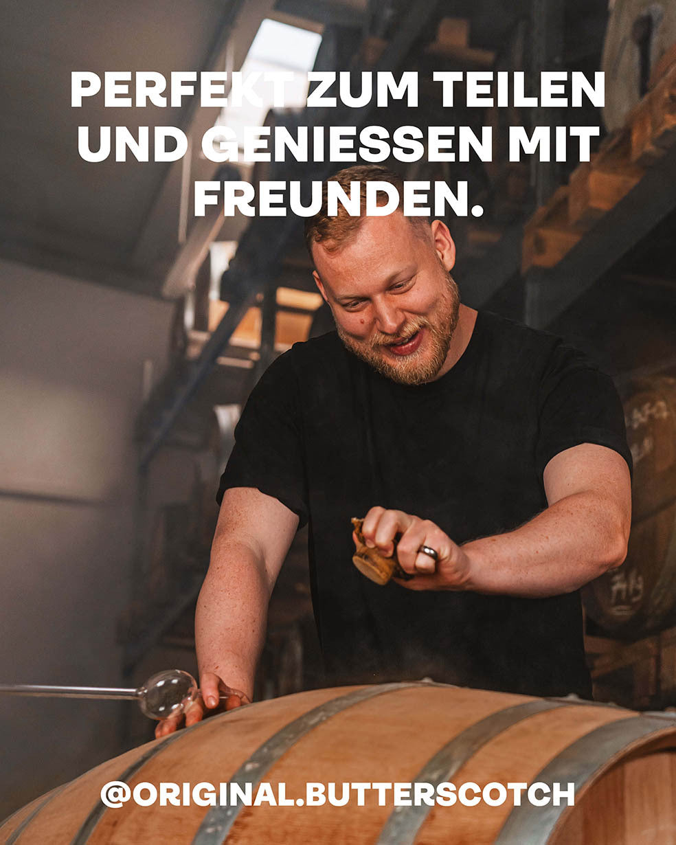 Butterscotch Single Malt Whiskey, Perfekt zum Teilen und Genießen mit Freunden, Brenner mit geöffnetem Whiskey-Holzfass im Vordergrund, Fasslager im dunklen Hintergrund