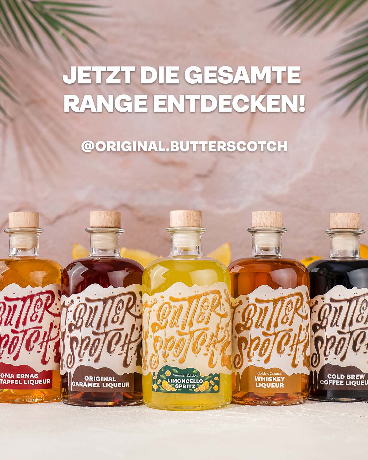 Butterscotch Range in einer Reihe, Bratapfel Likör, Caramel Likör, Limoncello Likör, Whiskey Likör, Cold Brew Coffee Likör, auf hellem Untergrund, Palmwedel und frische Zitronen im Hintergrund