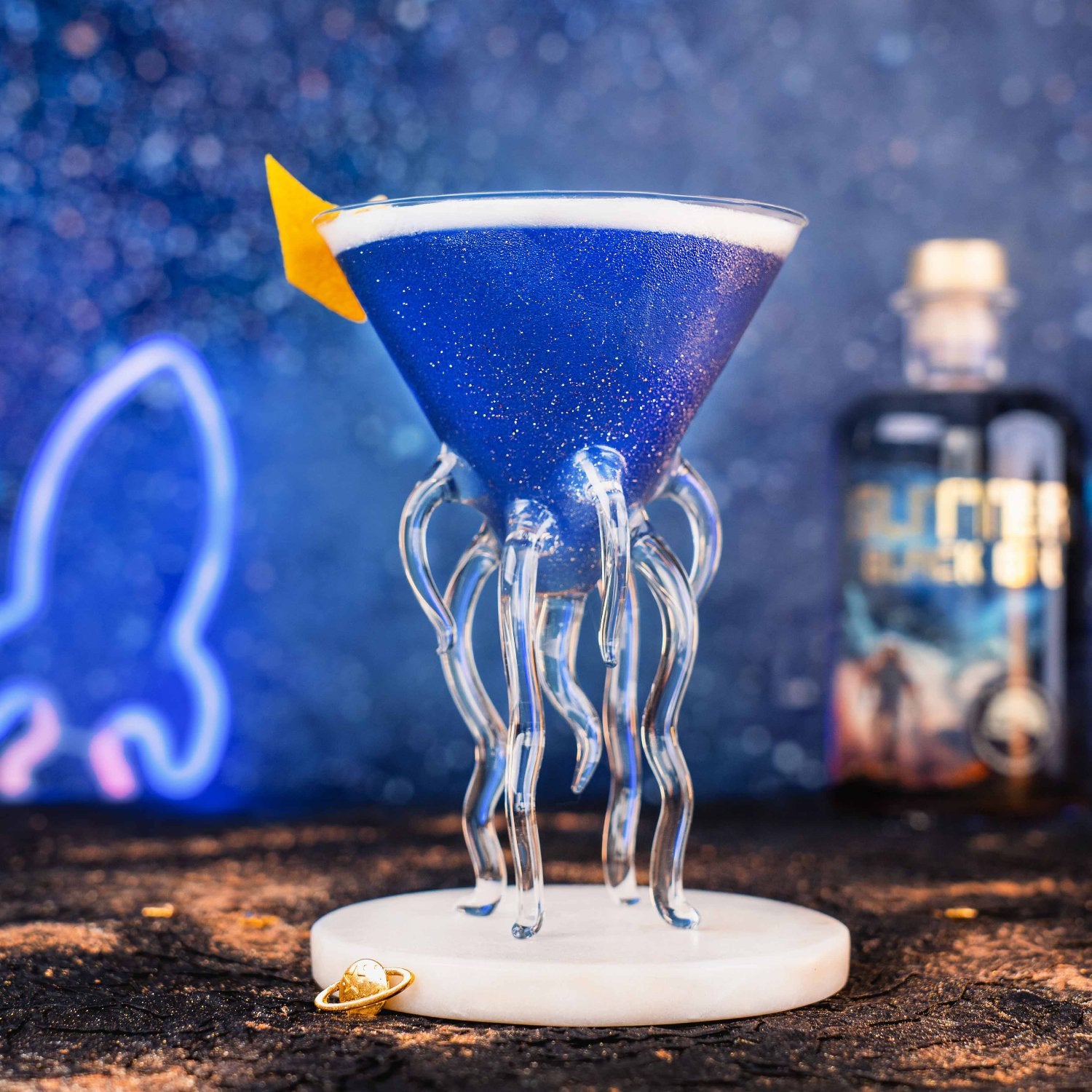 Glitter Black Gin - Blue Lady Cocktail in einem schimmernden blauen Glitzer-Cocktail, serviert in einem futuristischen Space-Martini-Glas.