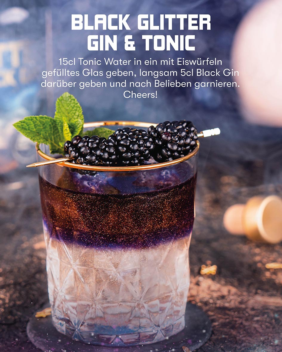 Black Glitter Gin & Tonic, 15cl Tonic Water in ein mit Eiswürfeln gefülltes Glas geben, langsam 5cl Black Gin darüber geben und garnieren, Zweifarbiger Cocktail garniert mit Brombeeren und Minze