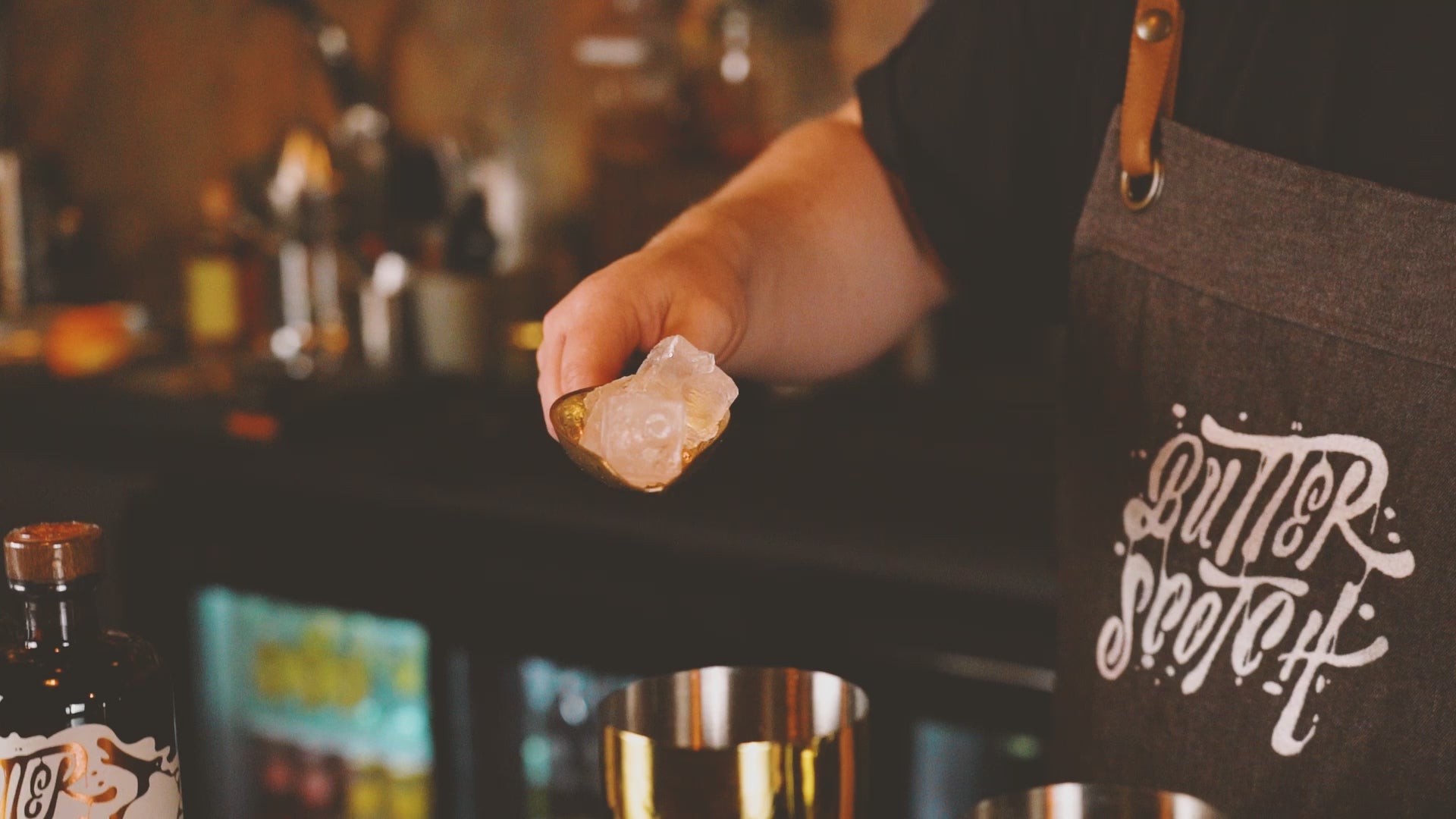 Butterscotch Single Malt Whisky, Whiskey Sour Cocktail vom Barkeeper zubereitet, auf einem Bar-Tresen vor einer Bar im Hintergrund